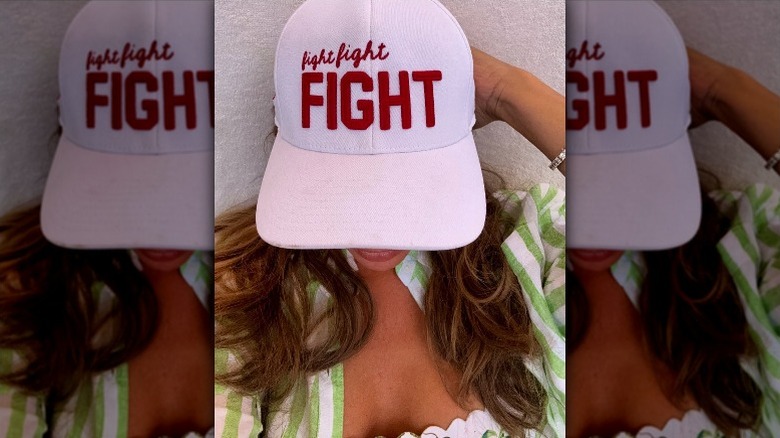 Alina Habba wearing a white hat that reads "fight, fight, fight" in red font