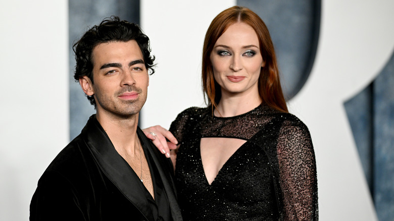 Sophie Turner with hand on Joe Jonas' shoulder