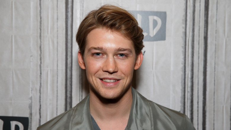 Joe Alwyn smiling on step and repeat