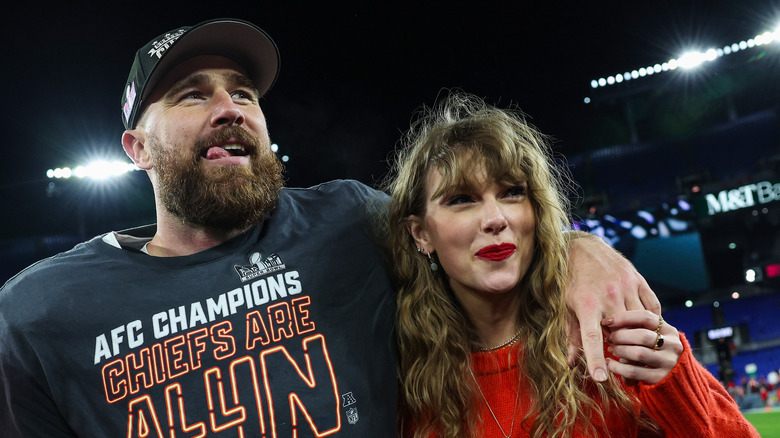 Travis Kelce and Taylor Swift stand together on football field