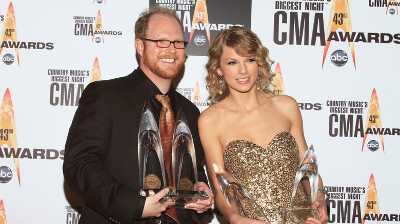 Nathan Chapman and Taylor Swift posing with awards