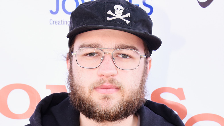 Angus T. Jones wearing a black cap