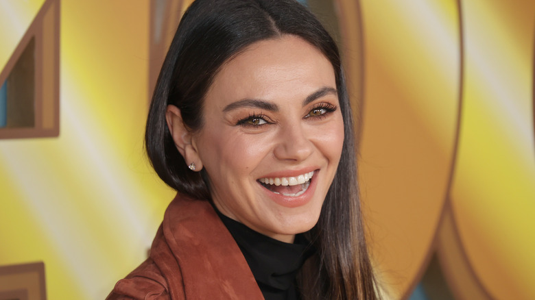 Mila Kunis laughing at event