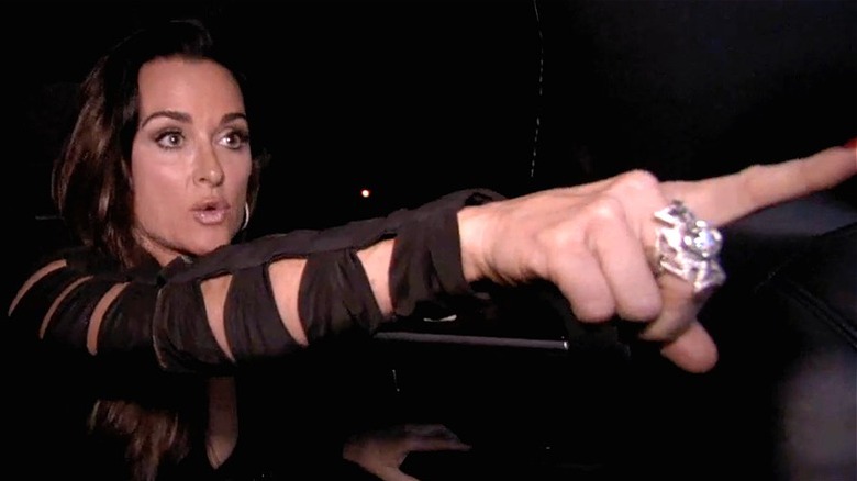 Kyle Richards pointing in a limo
