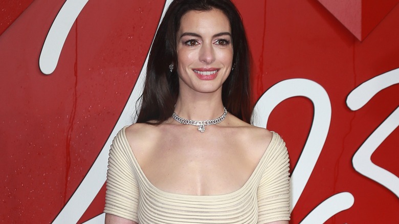 Anne Hathaway smiling, beige dress