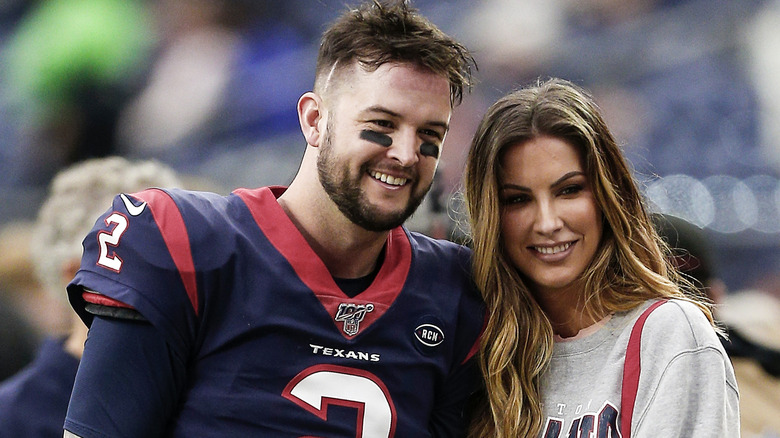 AJ McCarron and Katherine Webb posing for photos on the field