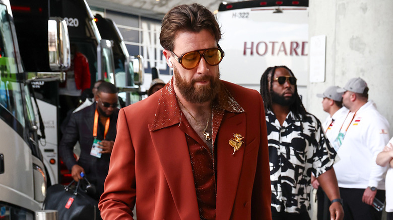 Travis Kelce arriving to the 2025 Super Bowl in rust-colored suit