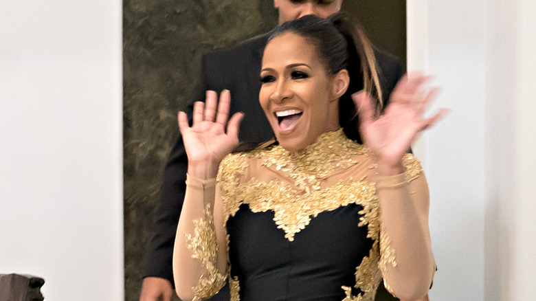 Sheree Whitfield smiling with arms up