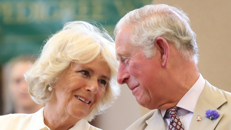 Camilla Parker Bowles and King Charles looking at each other.