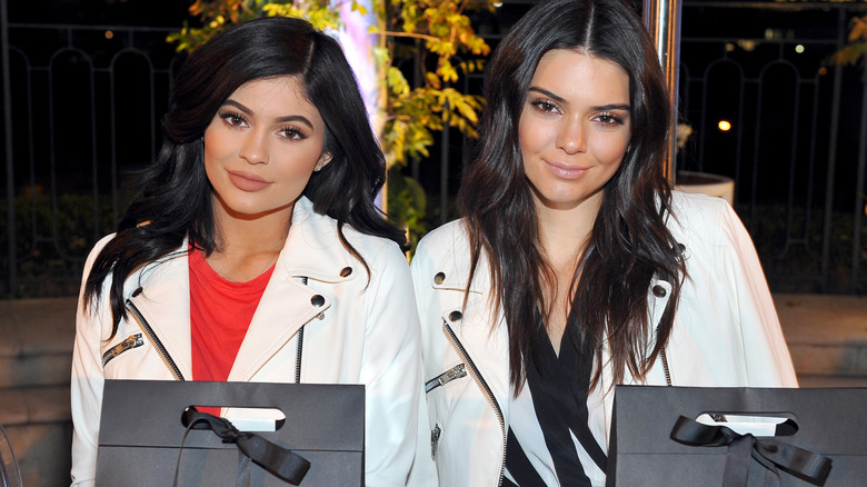 Kylie Jenner and Kendall Jenner posing for a photo wearing matching white jackets