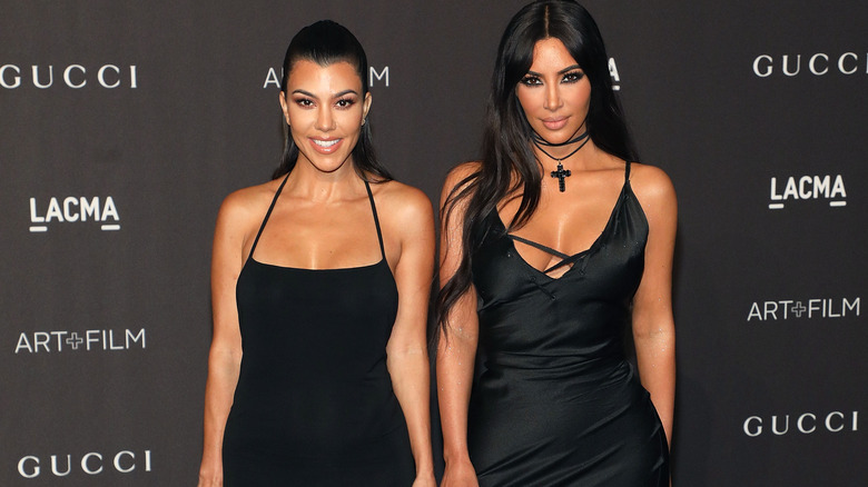 Kourtney Kardashian and Kim Kardashian at event
