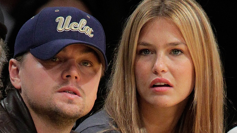 Leonardo DiCaprio and Bar Rafaeli watch basketball game 