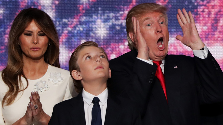 Barron Trump looking up beside parents