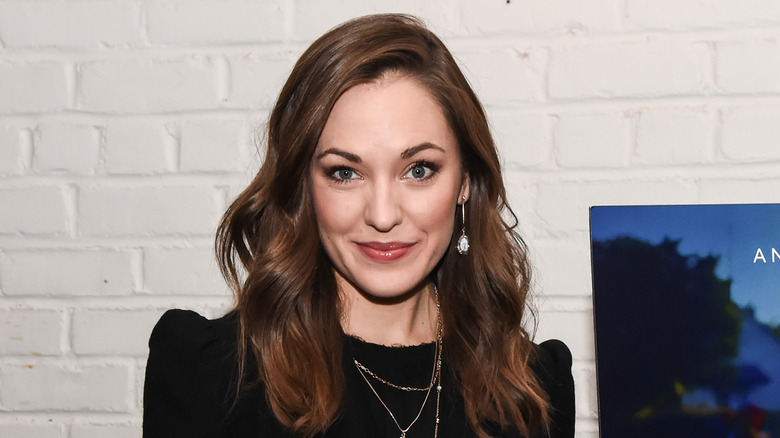 Laura Osnes smiling for cameras in black outfit