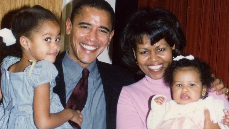 A young Barack and Michelle Obama with their daughters