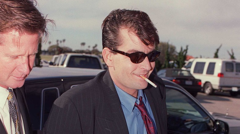 Charlie Sheen smiling, cigarette in mouth