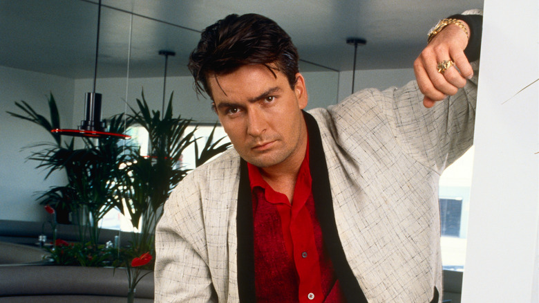 Charlie Sheen posing, arm leaning on wall