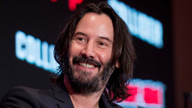 Keanu Reeves smiles onstage