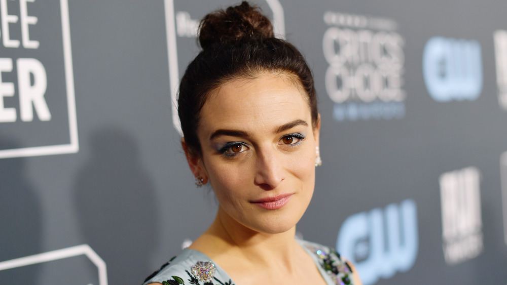 Jenny Slate with a very slight smile on the red carpet