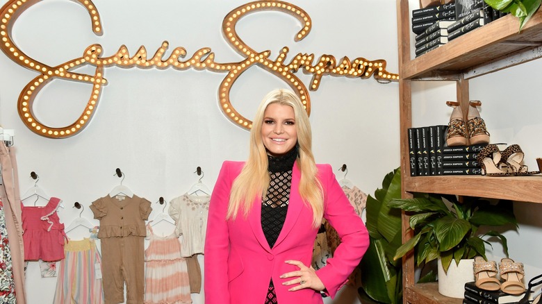 Jessica Simpson in front of her products