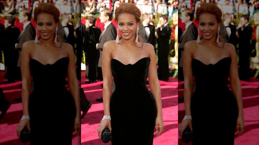 Beyoncé smiling in a black velvet dress at the 2005 Oscars