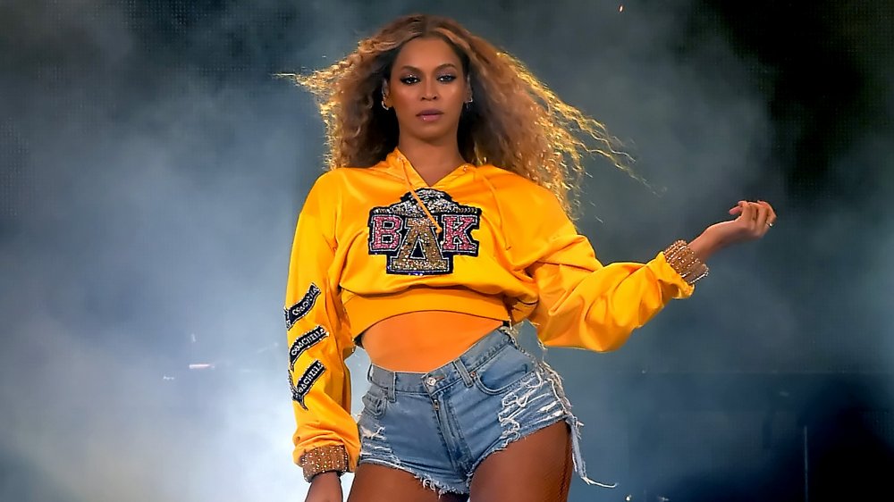 Beyoncé in a yellow cropped hoodie and jean shorts, performing at 2018 Coachella