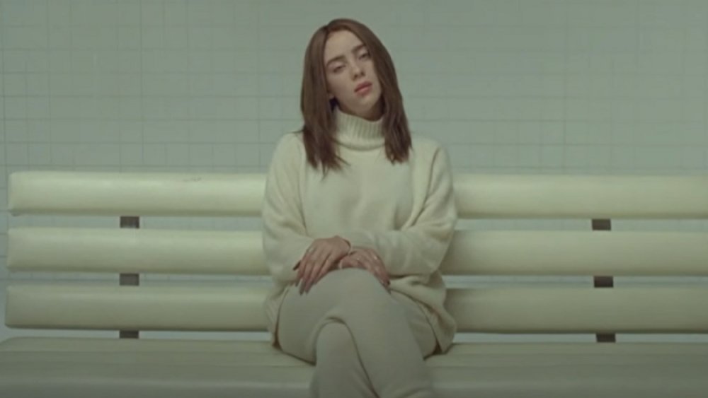 Billie Eilish in an all-white outfit and brown hair in her "Xanny" music video