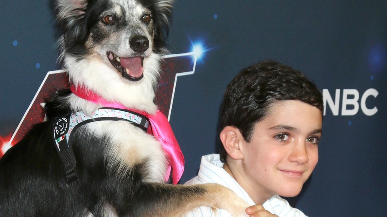 Eric Cowell posing with dog on red carpet