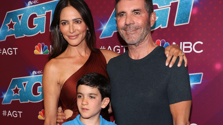 Eric Cowell, Simon Cowell, and Lauren Silverman smiling on AGT red carpet