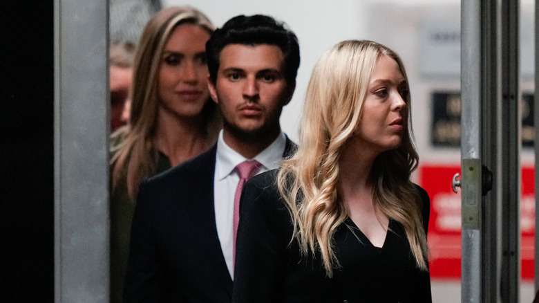 Michael Boulos walking out a door with Tiffany Trump