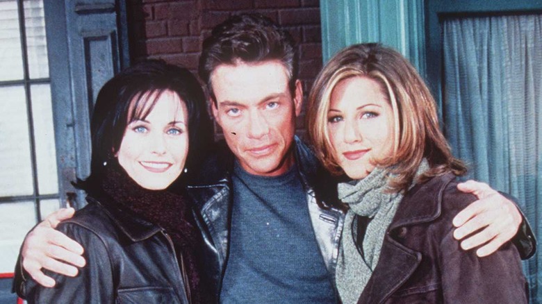 Courteney Cox, Jean-Claude Van Damme, and Jennifer Aniston posing