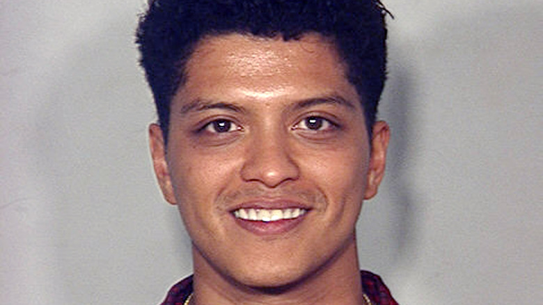 Bruno Mars ginning in his mugshot