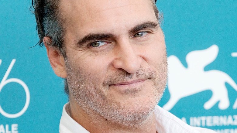 Joaquin Phoenix smirking to side