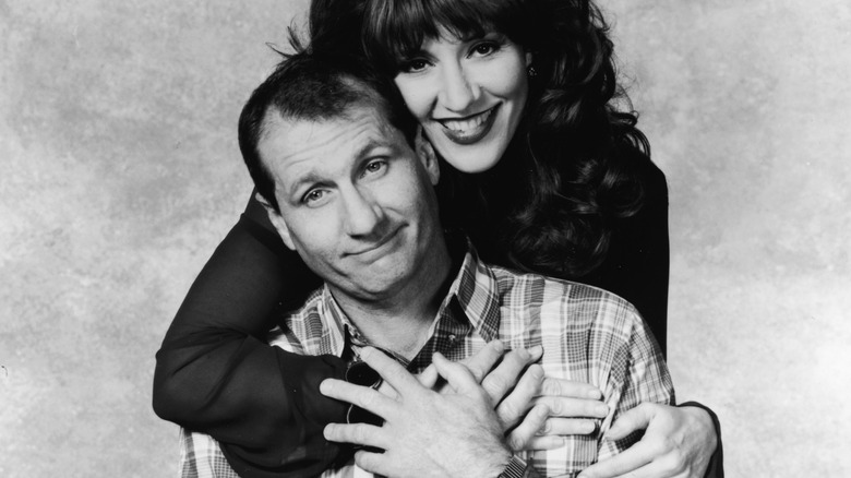 Ed O'Neill and Katey Sagal smiling on the set of Married with Children
