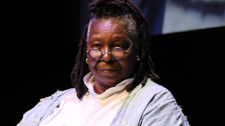 Whoopi Goldberg seated and looking away