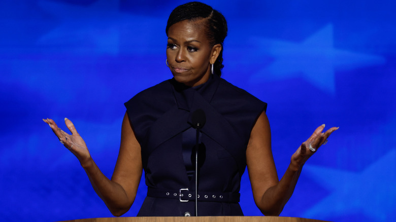 Michelle Obama gestures while addressing an audience.