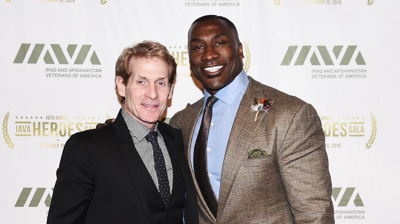 Skip Bayless posing with Shannon Sharpe on a red carpet