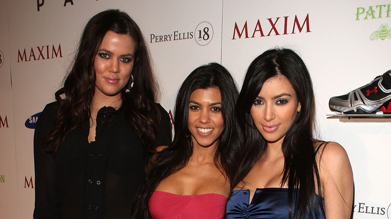 Khloé, Kim, and Kourtney Kardashian posing on red carpet together