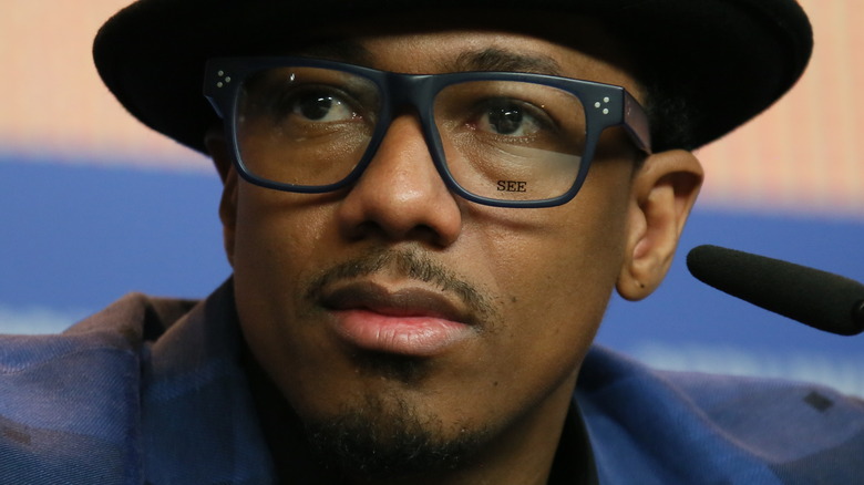 Nick Cannon wearing hat and glasses