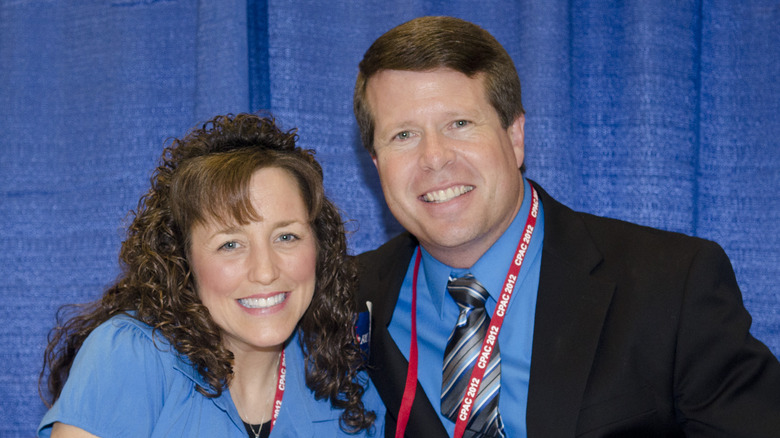 Michelle Duggar sitting next to Jim Bob Duggar smiling