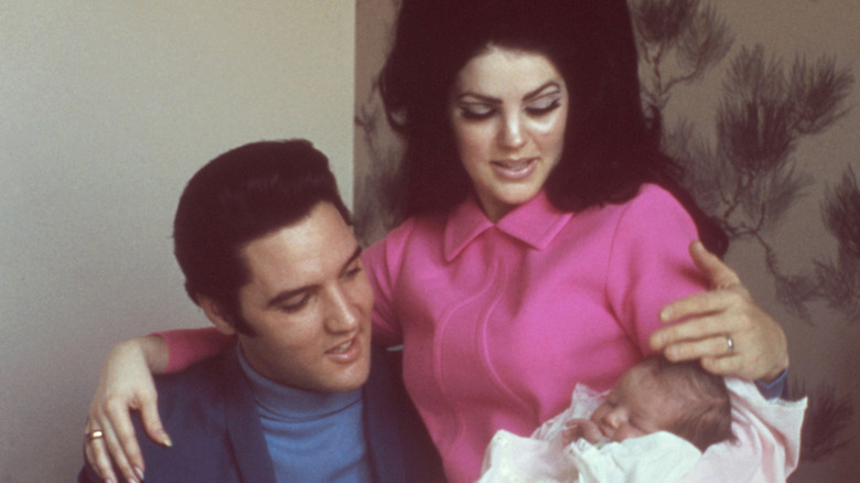 Elvis and Priscilla Presley sit with baby Lisa Marie