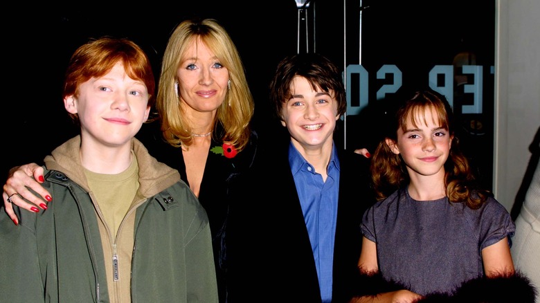 rupert grint, jk rowling, daniel radcliffe, and emma watson on a red carpet