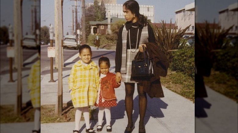 Young Kamala Harris standing with her mother and sister