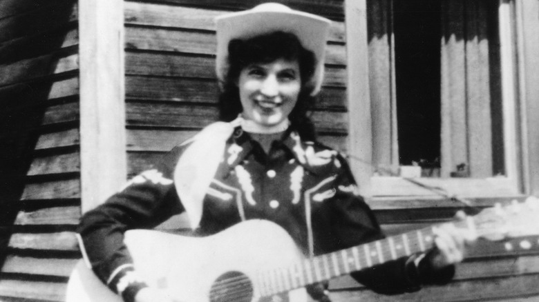 Loretta Lynn in 1960, with guitar and cowboy hat