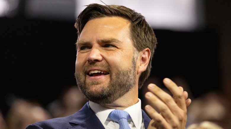 JD Vance clapping while wearing a suit and smiling