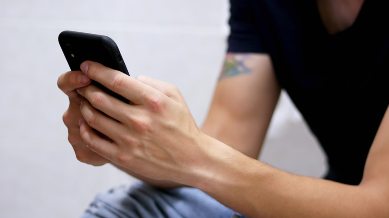 Man on phone in bathroom