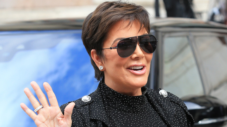 Kris Jenner wearing sunglasses and waving