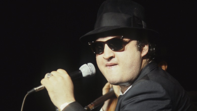 John Belushi holding microphone