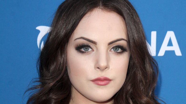 Liz Gillies with black curled hair