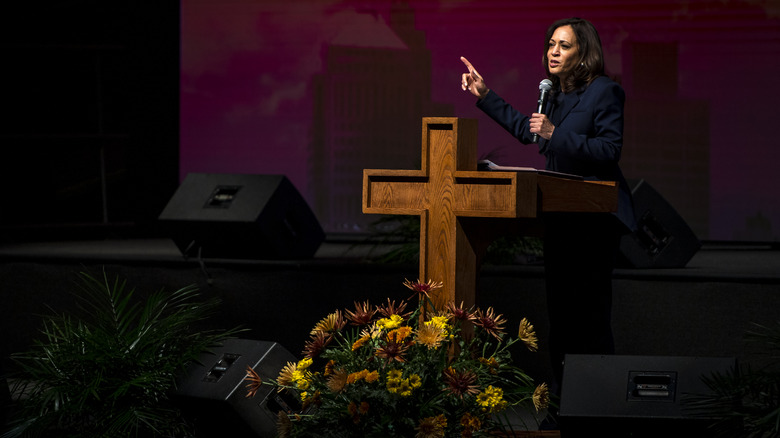 Kamala Harris speaks at a church behind a cross-shaped podium